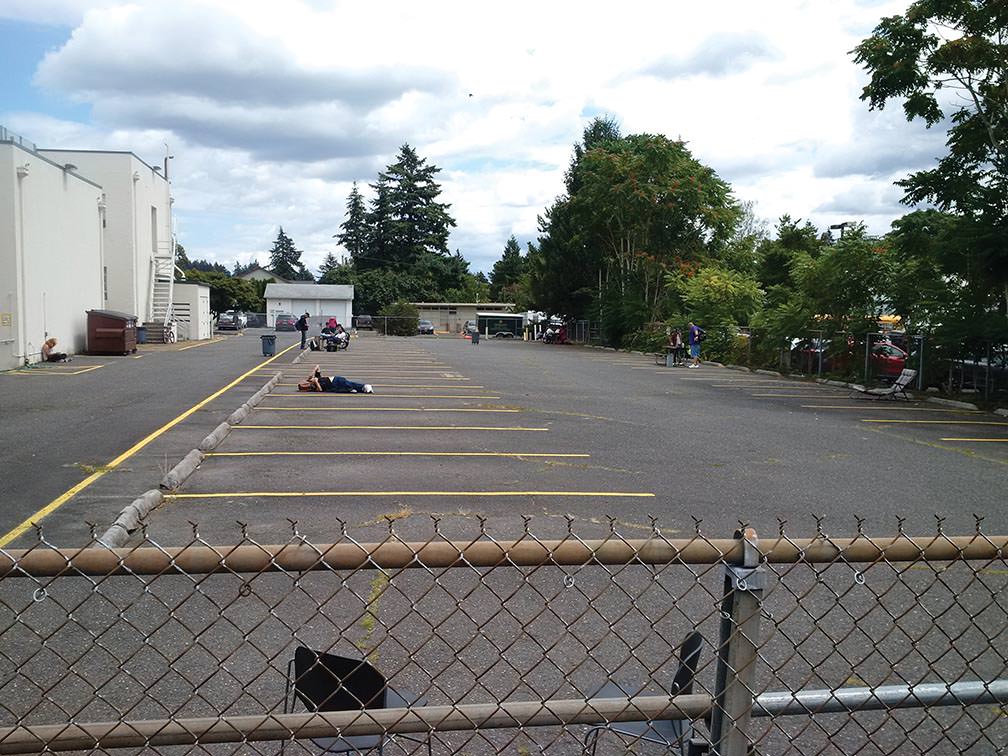 Since there is no hanging out inside the Hansen Shelter sleeping rooms during the day for the homeless, the parking in the back lot that faces 122nd Avenue will do for some.